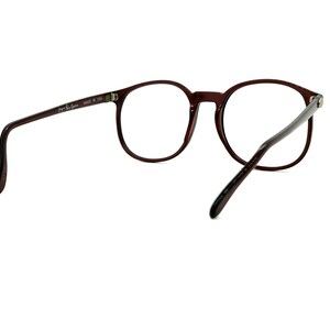 May include: A pair of brown, round spectacles with clear lenses. The glasses have a thin, metal frame and are made in the USA.