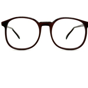 May include: A pair of brown round spectacles with clear lenses.