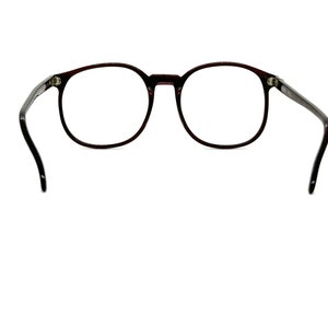 May include: A pair of round, dark brown spectacles with black arms.