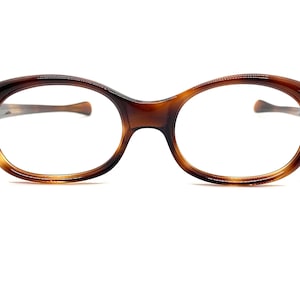 May include: A pair of brown tortoise shell oval-shaped eyeglasses with clear lenses.
