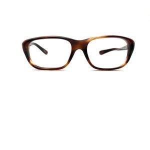 May include: Tortoiseshell pattern eyeglasses. The glasses feature a classic rectangular frame with clear lenses and dark temples. The frame's brown and amber tones create a stylish appearance. The glasses are suitable for everyday use.