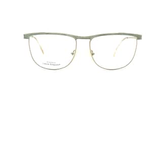 May include: Eyeglasses with a gold-colored frame and a light green top bar. The lenses are clear, and the frame has a half-rim design. The text "Laura Biagiotti" is printed on the lower left lens.