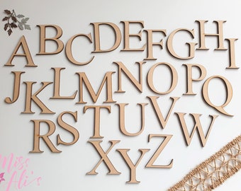 May include: A set of 26 wooden letters in uppercase, painted in a light brown color. The letters are arranged in alphabetical order, with the first row containing A through I, the second row containing J through Q, the third row containing R through W, and the fourth row containing X through Z.