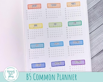 May include: A B5 common planner with monthly calendar pages for the year 2025. Each month has a colorful title bar with the month name and the days of the week abbreviated. The planner is printed on white paper with a grid pattern.