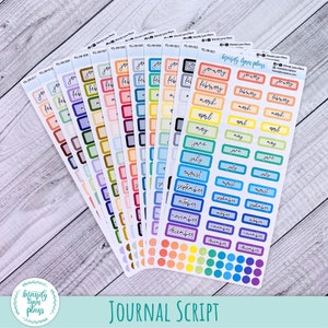 Puede incluir: Un conjunto de 12 pegatinas de planificador mensual de colores con una variedad de esquemas de colores y dise&ntilde;os. Las pegatinas presentan los meses del a&ntilde;o en una fuente manuscrita. Las pegatinas est&aacute;n dispuestas en forma de abanico sobre una superficie de madera. El texto "JOURNAL SCRIPT" est&aacute; impreso en la parte inferior de la imagen.