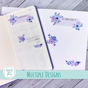 May include: A set of planner stickers with floral designs in shades of purple and blue. The stickers feature the text "This planner belongs to:" and "Hobonichi Techo 2023".