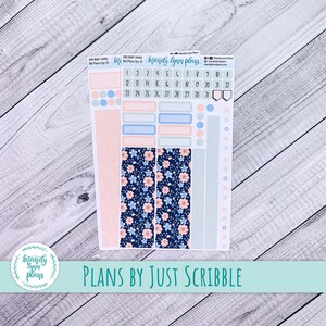 May include: A planner sticker sheet with floral patterns and the text "Mandy Lynn Plans" and "Plans by Just Scribble". The stickers are in blue, pink, and peach. The sheet includes date stickers and decorative elements for planning.
