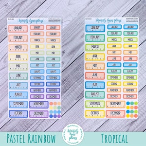 K&ouml;nnte beinhalten: Zwei Bl&auml;tter mit bunten monatlichen Kalenderausklebern. Das erste Blatt ist mit "Pastell Regenbogen" beschriftet und zeigt pastellfarbene Regenbogen-Monatsaufkleber mit den Monaten des Jahres und den Wochentagen. Das zweite Blatt ist mit "Tropisch" beschriftet und zeigt leuchtend bunte, tropische Monatsaufkleber mit den Monaten des Jahres und den Wochentagen.