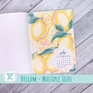 Puede incluir: Cuaderno abierto con papel cuadriculado a la izquierda y una página de vitela a la derecha. La vitela presenta un diseño de acuarela de limones con hojas verdes y el mes de julio. Texto: "VELLUM - MULTIPLE SIZES".
