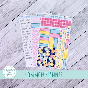 Puede incluir: Pegatinas para planificador con una variedad de diseños, incluyendo patrones geométricos rosas y azules, y motivos de limones y flores. Las pegatinas llevan el texto "Mandy Lynn Plans" y "Common Planner".