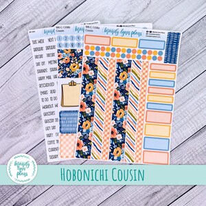 May include: Planner stickers featuring floral and geometric designs in navy, peach, and blue. The stickers include labels for scheduling and planning, with the text "Hobonichi Cousin" at the bottom. The Mandy Lynn Plays logo is also visible.