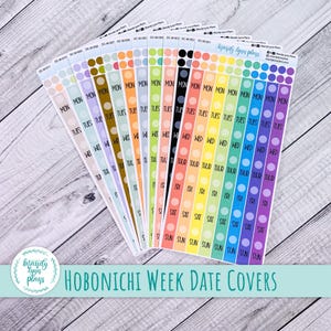 Puede incluir: Un conjunto de pegatinas de planificación coloridas con los días de la semana impresos. Las pegatinas, etiquetadas como "Hobonichi Week Date Covers", están dispuestas sobre una superficie de madera clara. Cada pegatina tiene los días de la semana impresos.