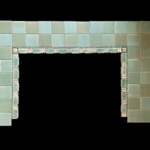 May include: A green and white tiled fireplace surround with a decorative border. The tiles are arranged in a checkerboard pattern.