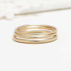 May include: A set of three gold stacking rings. The rings are simple and delicate, and they would make a great gift for a friend or loved one.