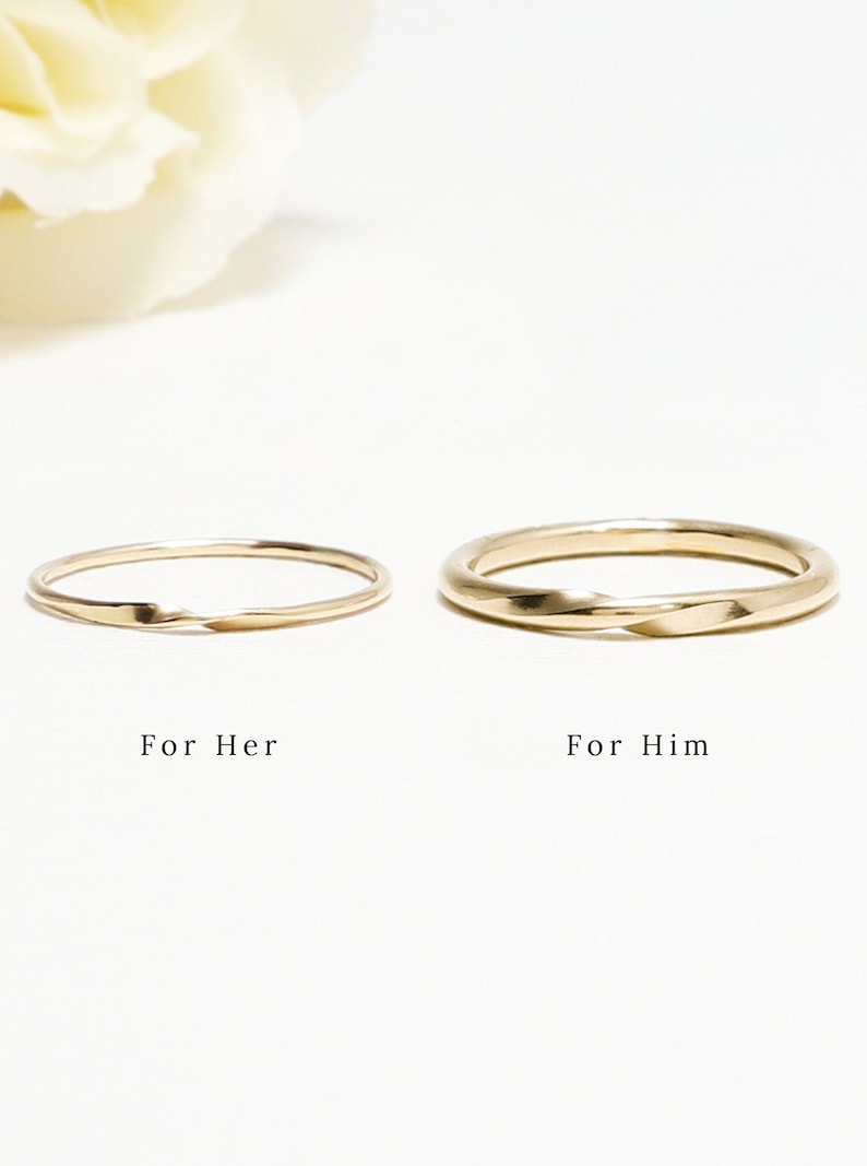 May include: Two gold wedding bands, one with a twisted design and the other with a smooth finish. The bands are displayed on a white background with the text "For Her" and "For Him" below each band.