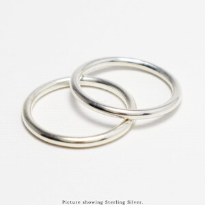 May include: Two silver rings, interlocked, against a white backdrop. The rings are smooth and shiny. The image text says "Picture showing Sterling Silver. Available in 14K Gold-Filled, 14K Rose Gold-Filled, and Sterling Silver."