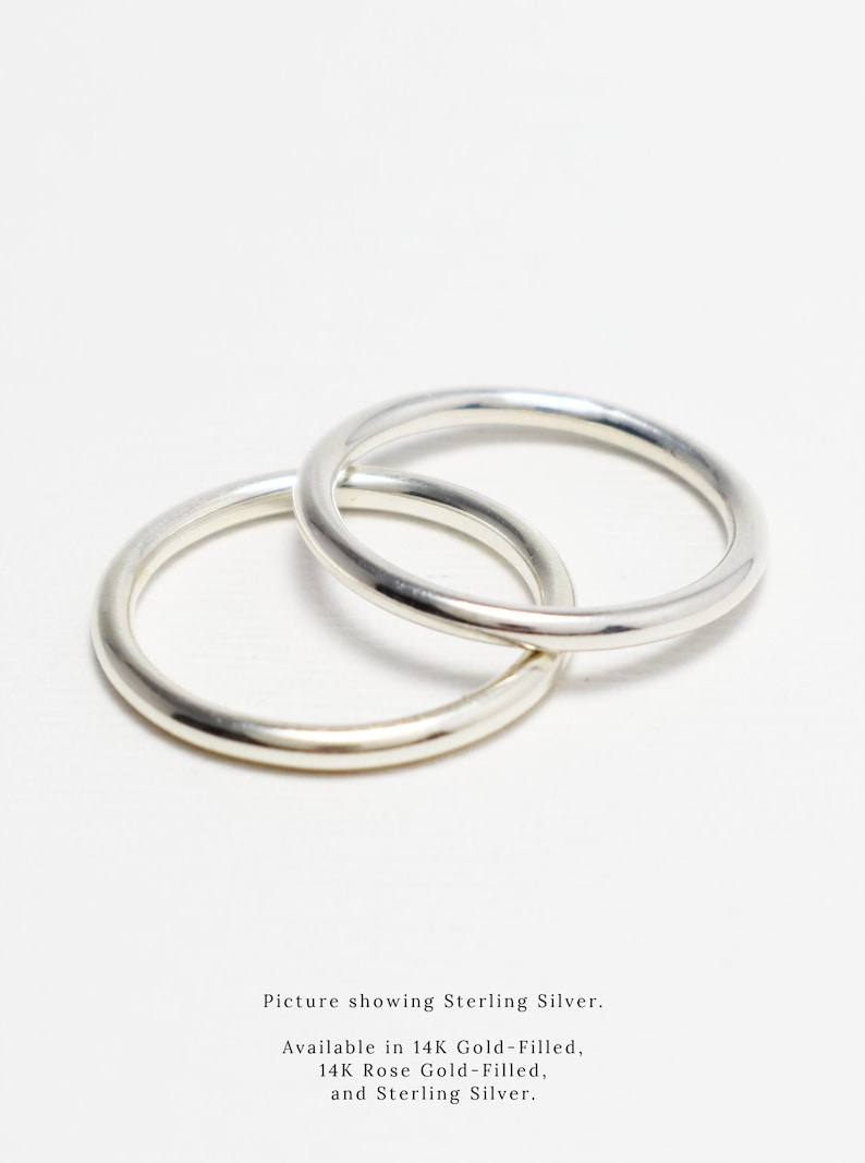 May include: Two silver rings, interlocked, against a white backdrop. The rings are smooth and shiny. The image text says "Picture showing Sterling Silver. Available in 14K Gold-Filled, 14K Rose Gold-Filled, and Sterling Silver."