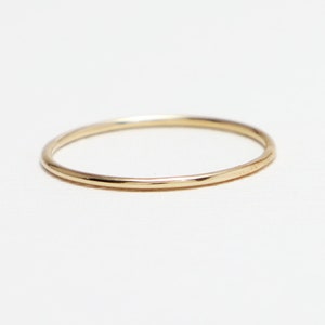 Peut inclure: Une bague simple en or. La bague est fine et a une finition lisse et polie.