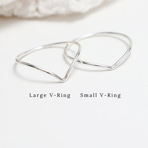May include: Two silver V-shaped rings, one larger and one smaller, on a white background.  Large V-Ring Small V-Ring