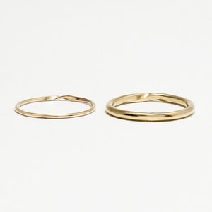 May include: Two gold rings, one with a twisted design and the other with a smooth finish.