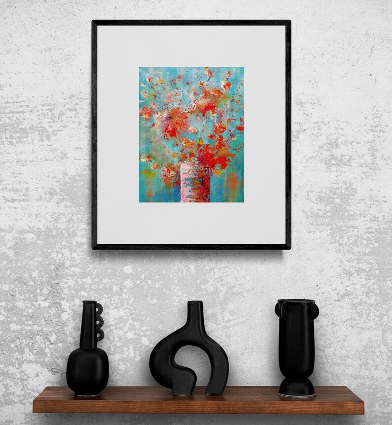 May include: A framed abstract painting of a bouquet of red, orange, and pink flowers in a white vase against a blue background.