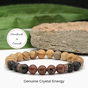 May include: A brown, red and black beaded bracelet with a "Handmade in Canada" label. The bracelet is made with natural stones and lava beads. Genuine Crystal Energy.