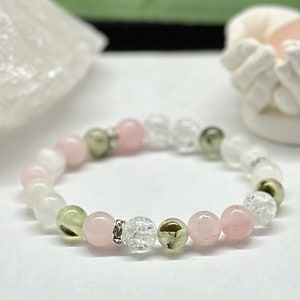 Peut inclure: Un bracelet composé de perles roses, vertes et transparentes. Les perles sont enfilées sur un cordon élastique transparent.