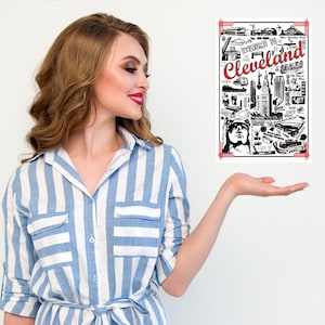 Puede incluir: Una mujer con una camisa a rayas azules y blancas extiende la mano para mostrar una ilustración en blanco y negro de Cleveland, Ohio. La ilustración está rodeada por un borde rojo y contiene el texto "Cleveland".