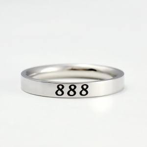 May include: A silver band ring with the number 888 engraved on the top.
