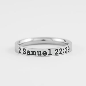May include: A silver ring with the inscription "2 Samuel 22:29" in black lettering. The ring is thin and has a polished, reflective surface. The background is plain white.