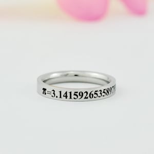 May include: A silver ring with the mathematical constant pi, "π = 3.14159265358979", engraved around the band.