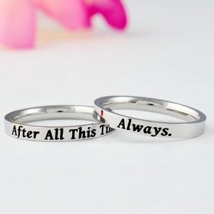 May include: Two silver rings with the inscription "After All This Time" and "Always." on them.