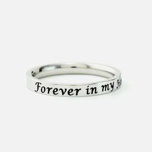 May include: A silver ring with the inscription "Forever in my heart" engraved on the band.