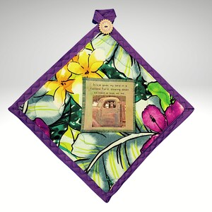 May include: Purple quilted hot pad with a floral print and a vintage car image with the text "It's a goat my lord in a Flatbed Ford, slowing down to take a look at me."