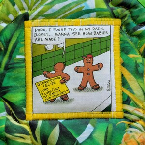 May include: A fabric patch with a cartoon scene of two gingerbread men. One holds a recipe card that reads "Gingerbread recipe: 1 egg, 3 cups flour, 1 tsp vanilla, 1 cup molasses." The patch is on a tropical print background.