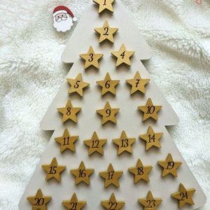 Tree-shaped wooden Advent calendar with engraved stars and hand-painted Santa Claus