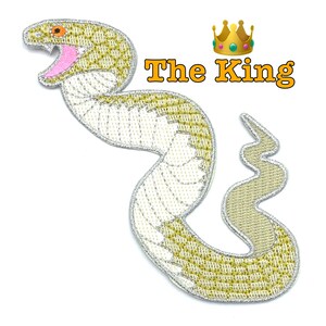 May include: An embroidered iron-on patch of a white snake with a yellow pattern and a pink mouth. The snake is curled in an 'S' shape. The text 'The King' is above the snake in yellow letters.