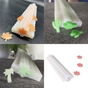 Peut inclure: Trois moules en silicone pour faire du savon ou des bougies. Les moules sont blancs et présentent différents motifs : une feuille d’érable, un cactus et un palmier.