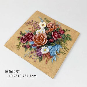 May include: A 3D wall art plaque featuring a bouquet of flowers in shades of red, orange, pink, white, and blue. The flowers are arranged in a realistic style and appear to be sculpted from the plaque. The plaque is made of a light brown material and has a textured surface. The plaque measures 19.7 inches by 19.7 inches by 2.7 inches.