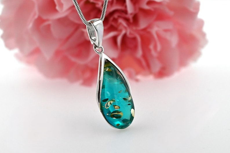 May include: A teardrop-shaped pendant necklace with a blue and gold amber stone set in a silver frame.