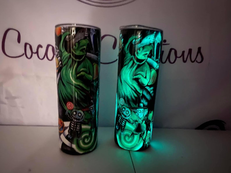 May include: Two glow-in-the-dark tumblers with a green and black design featuring the character Jack Skellington from the movie The Nightmare Before Christmas.