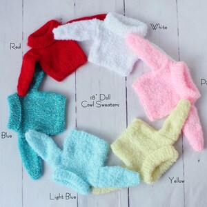 May include: Seven 18 inch doll cowl sweaters in various colors: red, white, pink, blue, light blue, yellow.  The sweaters are arranged in a circle on a white wooden background.  18" Doll Cowl Sweaters
