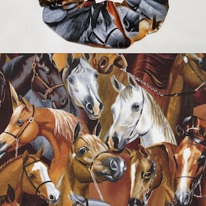 Könnte beinhalten: Ein braunes, graues und weißes Haargummi mit einem Pferde-Druck. Das Haargummi ist aus Stoff und hat ein gerafftes Design.