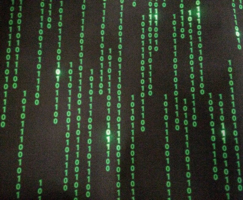 Puede incluir: Un fondo negro con un patr&oacute;n de 1 y 0 verdes, que se asemeja a un c&oacute;digo digital o una secuencia de datos binarios.