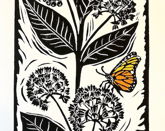 May include: Black and white linocut print of a monarch butterfly on a milkweed plant. The butterfly is orange and black with white spots. The milkweed plant has black leaves and white flowers.