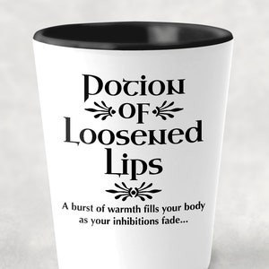 May include: White shot glass with a black rim. The glass has black text that reads "Potion of Loosened Lips" with a decorative flourish above and below the text. Below the text is a smaller font that reads "A burst of warmth fills your body as your inhibitions fade..."