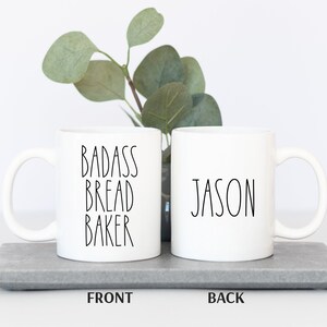 May include: White ceramic mug with black text that reads "Badass Bread Baker" on the front and "Jason" on the back.