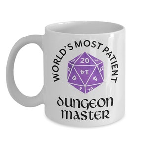May include: White ceramic mug with a black and purple design. The mug reads "World's Most Patient Dungeon Master" with a purple 20-sided die in the center.
