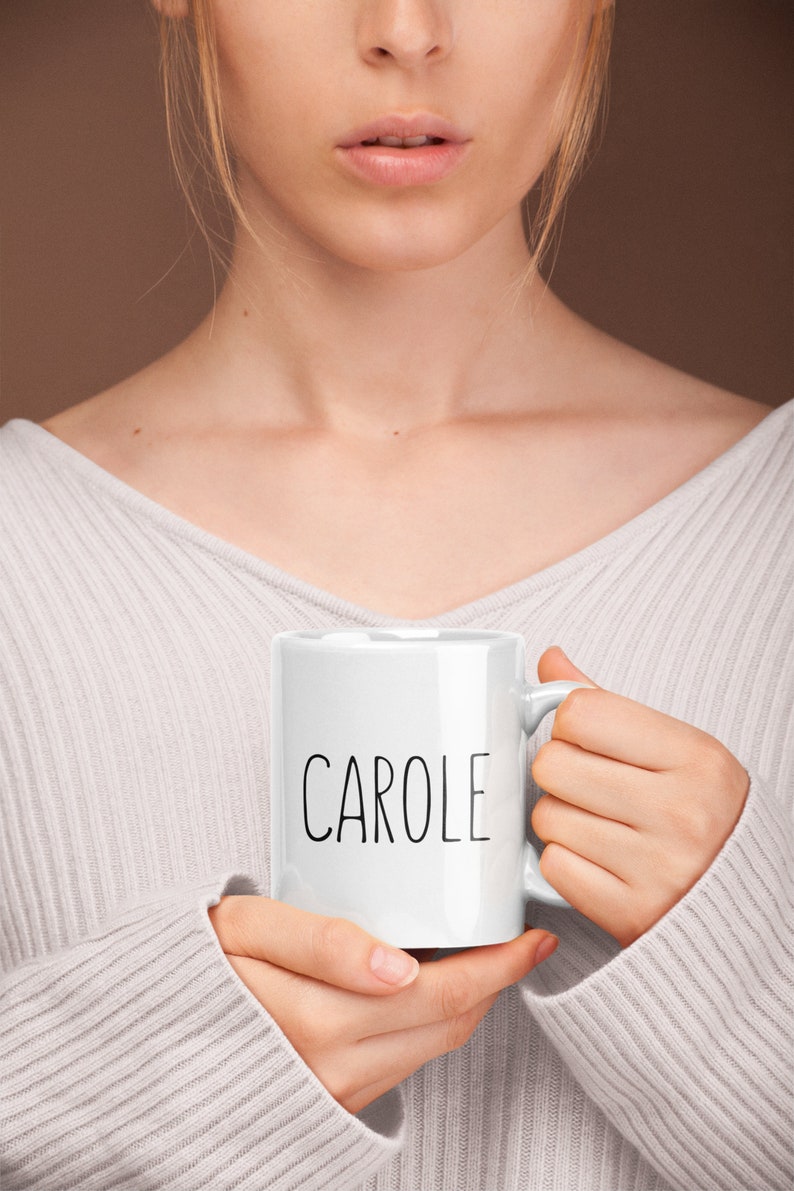 May include: White ceramic mug with the name "CAROLE" printed in black lettering.