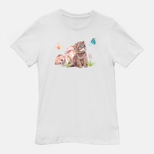 May include: White t-shirt with a watercolor illustration of two brown and orange kittens playing in a field of flowers and butterflies.